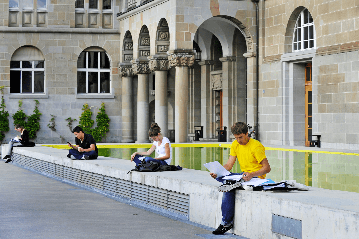 Students sit on a low wall outside Zurich stadium