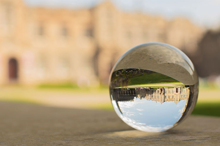 An inverted image of a lens ball in front of university buildings