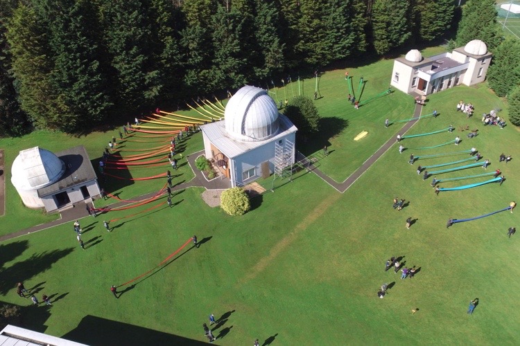 Students attempting to create the largest Neon spectrum with colourful ribbons on the lawn besides the Observatory. 