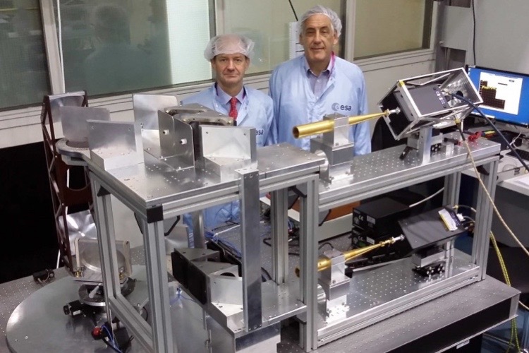 Two scientists standing behind of a scientific instrument.