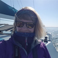 Emma, wearing a purple jacket and sunglasses on a boat on a sunny day